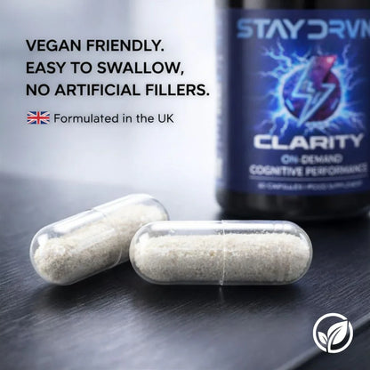 Two capsules and a bottle labeled 'Stay Drvn Clarity' on a reflective surface with text about vegan friendliness and artificial fillers.